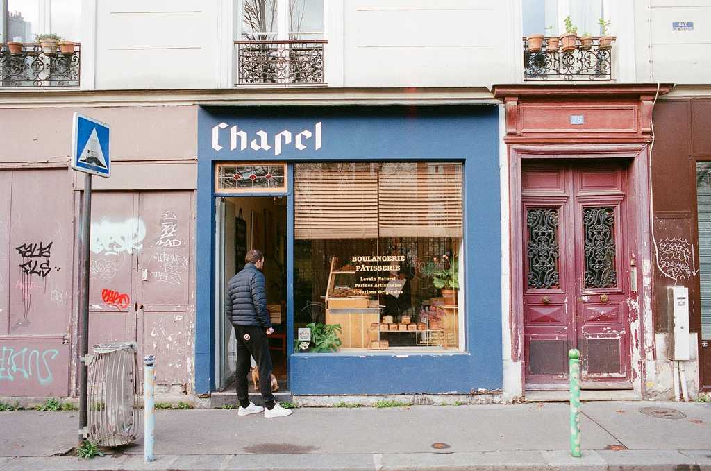 An independent bakery called Chapel, painted in blue with a customer standing by the door