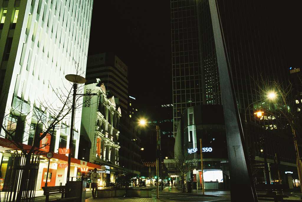 A street intersection at night surrounded by tall buildings
